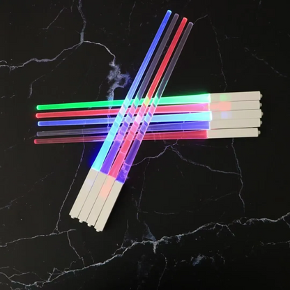 Set of glow sticks with colored ends on a black textured background